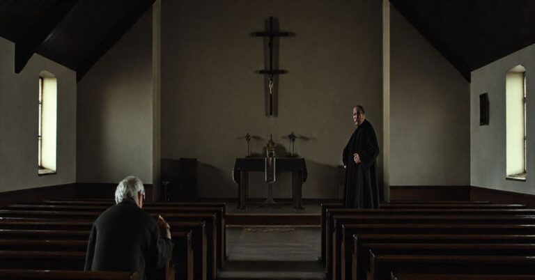 Ciemny, tradycyjny katolicki wnętrze nowoczesnego kościoła w Bilczy, przedstawiające minimalistyczny ołtarz z improwizowanym krzyżem między dwoma uczniami, przy przygasłodm oświetleniu. Na pierwszym planie staruszek modli się, podczas gdy postać podobna do ojca Piotra Ściegiennego stoi z buntowniczym wyrazem twarzy w cieniu. Scena oddaje upadek teologiczny, z pustymi ławkami i brakiem sakramentów, ukazując konflikt między ideałami rewolucyjnymi a autentycznym kultem katolickim.