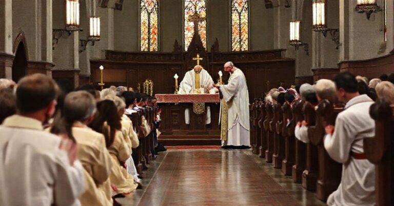 Wierni klęczący przy balaskach podczas przyjęcia Komunii Świętej w tradycyjnym kościele katolickim.