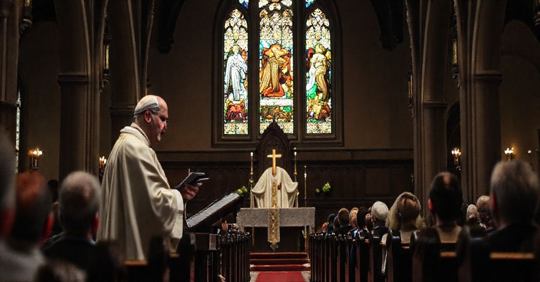 Biskup Roman Pindel głoszący homilię w tradycyjnym kościele katolickim podczas mszy św., z widocznymi witrażami przedstawiającymi Nimroda i Ezawa.