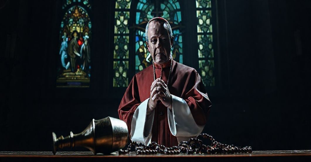 Biskup w tradycyjnym stroju biskupim stoi przed krzyżem, wyraz twarzy poważny i smutny. W tle witraż przedstawia Ostateczny Sąd, rzucając mroczny blask na scenę. Na pierwszym planie widnieje zardzewiały kielich i rozbity różaniec, symbolizujące profanację obowiązków sakralnych. Ręce biskupa są splączone w modlitwie, ale jego postawa wyrazuje rezygnację zamiast determinacji. Atmosfera przekazuje głęboką kryzys duchowy.