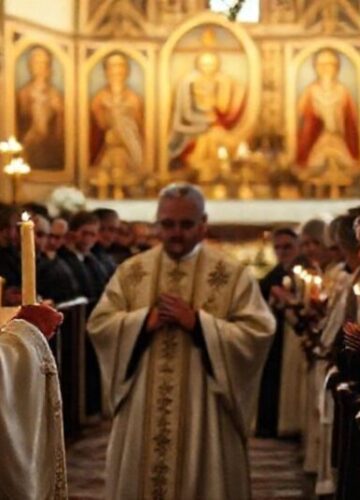 Sobór katolicki z tradycyjną ikonografią w Prałkowcach podczas ekumenicznego nabożeństwa. W tle widoczni są klerycy mitrat Bogdan Stepan i protojerej Jan Tarapacki. Scena jest poważna i poważna.