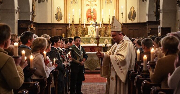 Uroczysta msza w tradycyjnym kościele katolickim z grupą harcerzy przekazującą świato Pokoju biskupowi Janowi Piotrowskiemu. Scena przedstawia kultowe elementy i symbolikę katolicką.