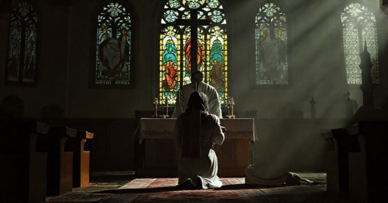 Juman Al Qawasmi klęcząca przed tradycyjnym katolickim ołtarzem z księdzem w sutannie i stole przyjmującym jej Eucharystię; w tle widoczne kontury meczetu.