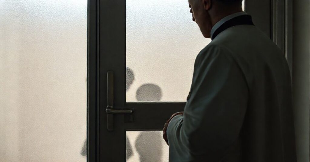 Kapelan katolicki modlący się przed zabytkowym drzwiami kliniki medycznej, trzymając krzyż z Jezusem. Scena podkreśla godność ludzkich istot i walkę Kościoła przeciwko pseudomedycznym praktykom.