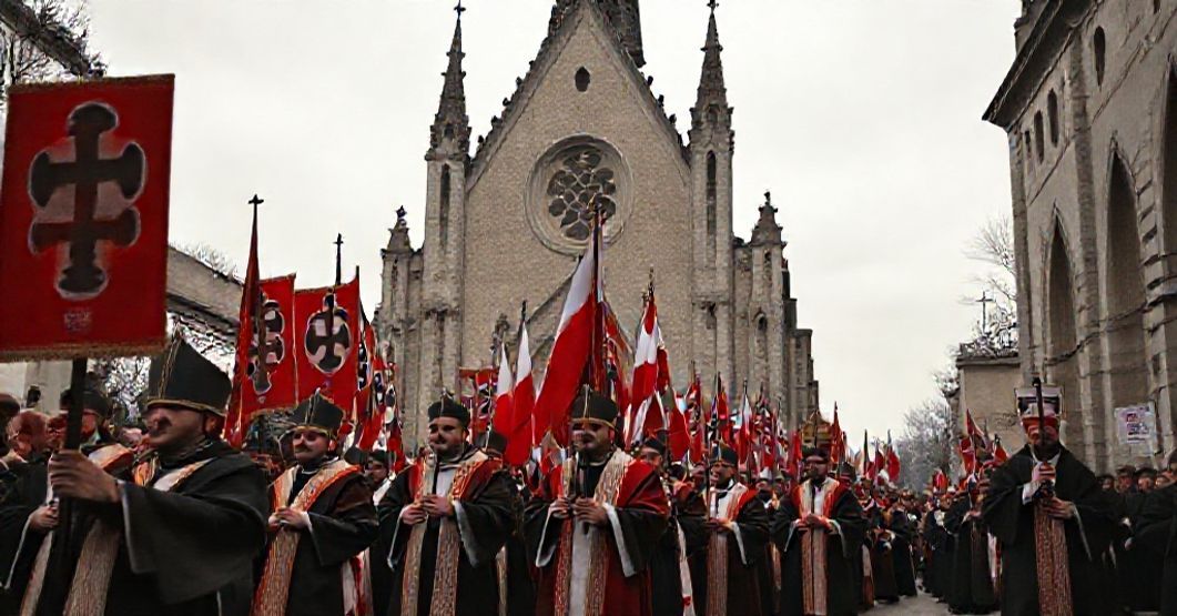 Pielgrzymka katolicka z tradycyjnymi szatami liturgicznymi i transparentami przedstawiającymi męczeństwo polskich salezjan w nazistowskich obozach koncentracyjnych.