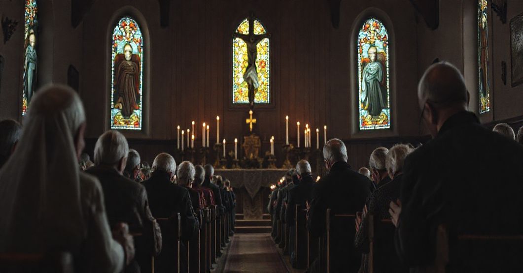 Starsi Sybiracy modlący się w tradycyjnym koście katolickim przed ołtarzem z krzyżem i świecznikami, z widocznymi witrażami przedstawiającymi Chrystusa Krola.
