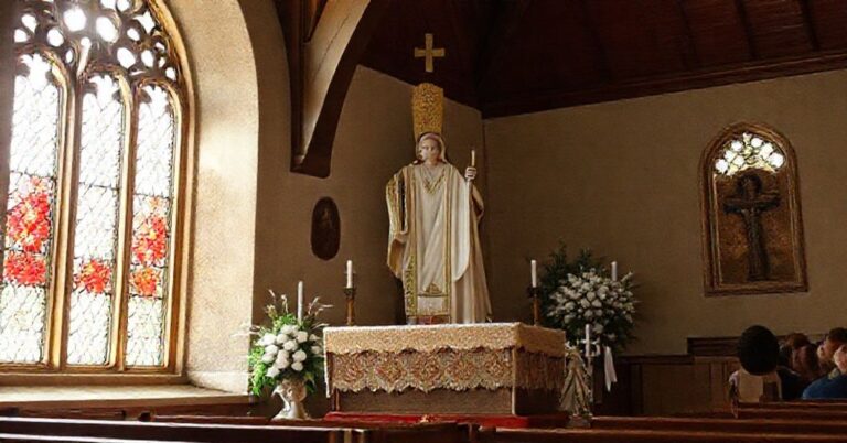 Katolicki kapłan modli się nad chorym w tradycyjnym domu pomocy społecznej, otoczony przez siostry szarytki. Sceny łaski i miłosierdzia w sakralnych domach pomocy.