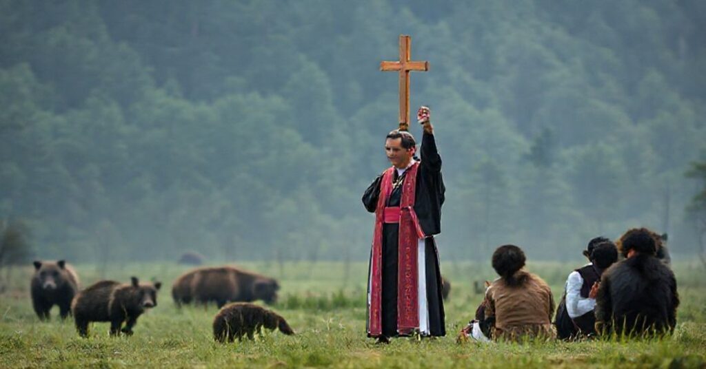 Książ katolicki w tradycyjnych szatach liturgicznych modli się w Japonii przy wsparciu wiernych, podczas gdy dzikie zwierzęta obserwują z odległości. Scena symbolizuje potrzebę pokuty i Bożej ochrony.