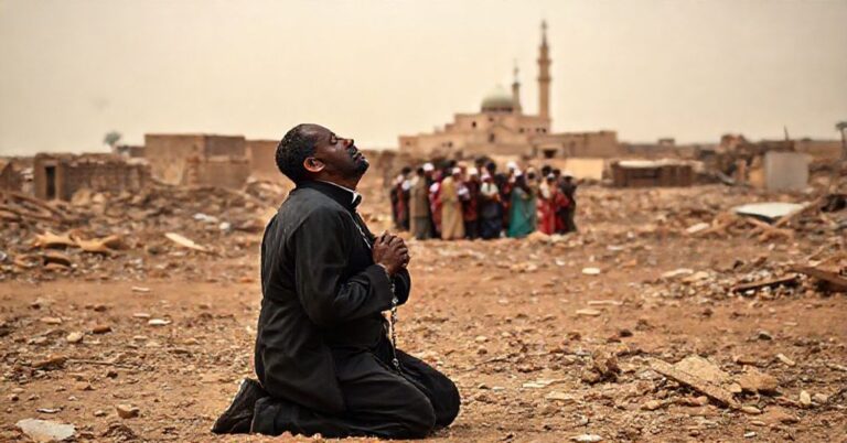 Scena w Sudanie w 2025 roku: katolicki misjonarz modli się w ruinach zniszczonej wsi.