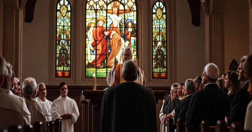 Grupa katolicka słuchająca przemowy w tradycyjnym kościele z ołtarzem i witrażami