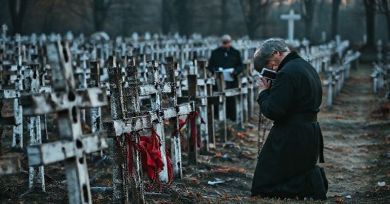 Uroczysty katolicki pomnik na cmentarzu w Katyniu z polskimi krzyżami usuwanymi przez rosyjskich urzędników. Przedstawione jest ciche modlitwy kapłana katolickiego w tle.