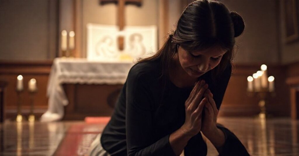 Kobieta modli się z żalem przed ołtarzem katolickim po aborcji