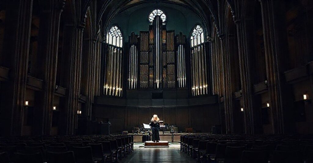 Wnętrze bydgoskiej świątyni przekształcone w salę koncertową z organami Walckera podczas Dni Muzyki Kościelnej. Prof. Anna Szarapka prowadzi koncert, wykonując utwory Bacha.