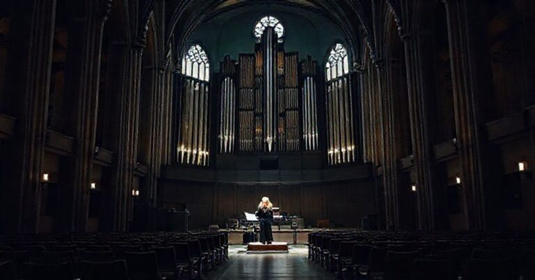 Wnętrze bydgoskiej świątyni przekształcone w salę koncertową z organami Walckera podczas Dni Muzyki Kościelnej. Prof. Anna Szarapka prowadzi koncert, wykonując utwory Bacha.