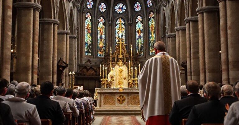 Biskup w tradycyjnych ornatach liturgicznych przewodniczy mszy trydentyńskiej w katedrze w Krakowie. Wierni klęczą w modlitwie podczas podniesienia hostii.