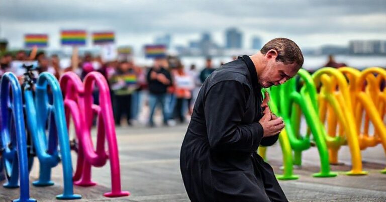 Katolicki ksiądz modli się przed tęczowymi stojakami na rowery w St. Petersburg na Florydzie