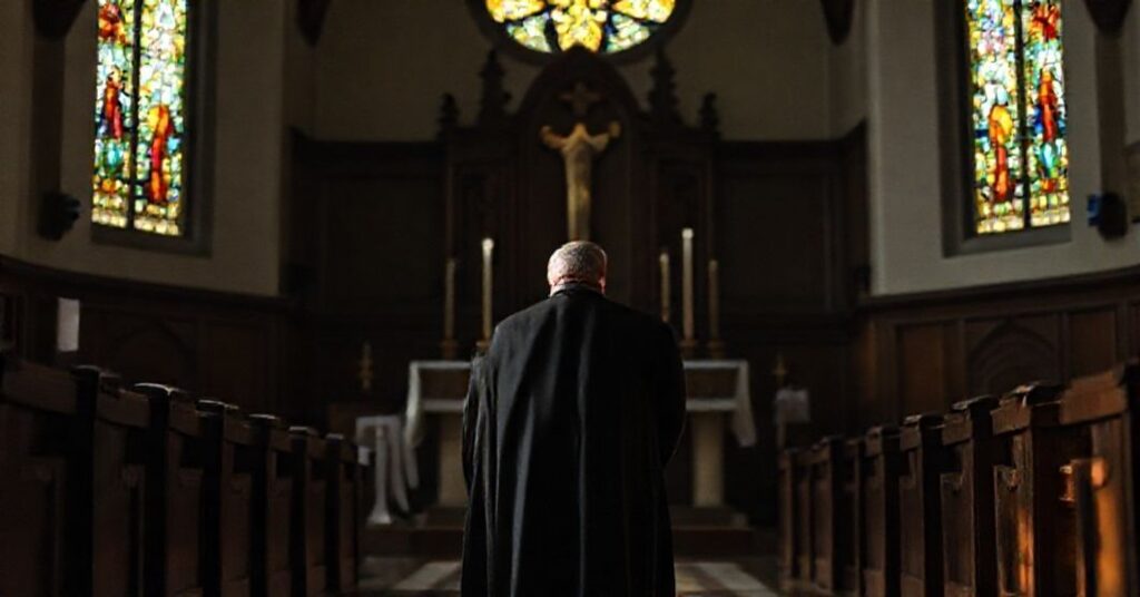 Portret tradycyjnego księdza w habitach przed tabernakulum w kościele katolickim