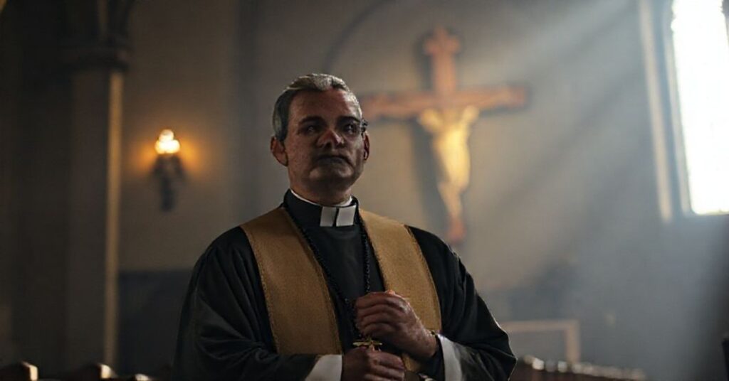 Ksiądz w tradycyjnych szatach liturgicznych stoi w oswietlonym kościele, trzymając różaniec. Tło przedstawia krzyż, symbolizujący prawdziwą misję Kościoła.