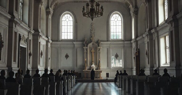 Solemne wnętrze barokowego pałacu w Łabuniach, symbolizujące duchową pusteń modernizmu w tradycyjnych murach, z widokiem na cmentarz z grobami rodziny Szeptyckich.