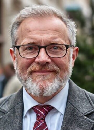 Modlitwa przedsiębiorcy - katolicki wgląd na biznes Młody przedsiębiorca modli się przed aniołem stróżem z księgą katolickiej nauki społecznej