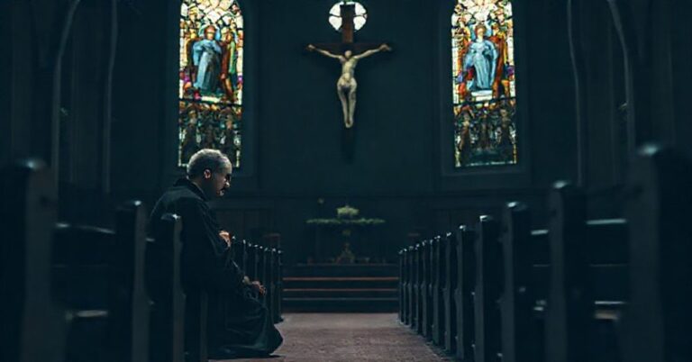 Pozbawiony nadziei katolicki kapłan modlący się przed krzyżem w opuszczonej kaplicy.