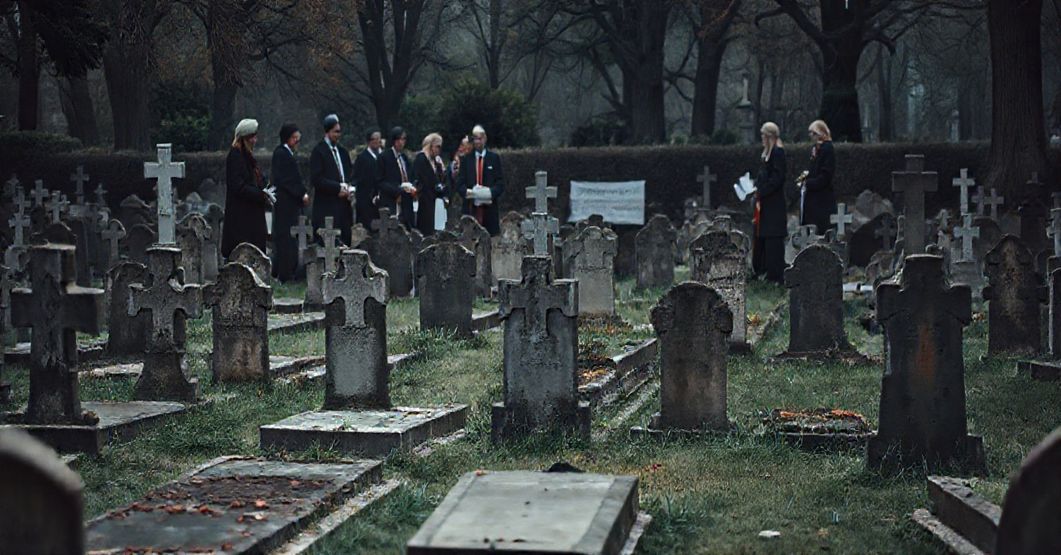 Stary, zaniedbany cmentarz katolicki z pomnikami wymagającymi naprawy, symbolizujący zanik duchowości w posoborowej "pastoracji". Na tle wolontariusze zbierają datki na renowację, ignorując modlitwę za dusze. atmosfery smutnej, podkreślającej krytykę nekrofilii w "pastoracji" w Kielcach.
