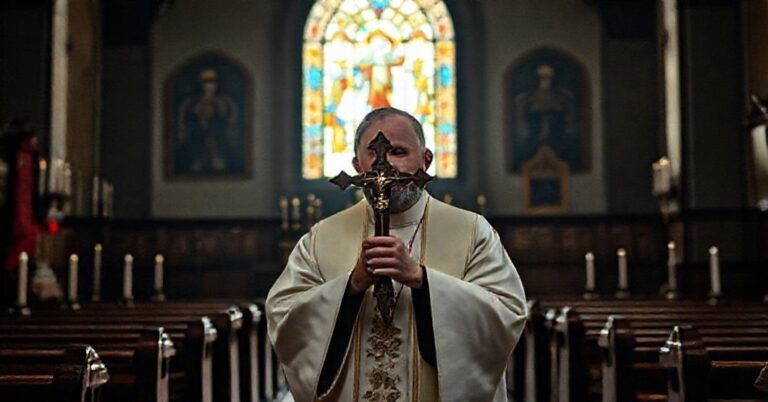 Ksiądz w tradycyjnych szatach liturgicznych stoi w kościele z ikonami i świecami, symbolizując walkę polskich duchownych w Rosji i na Białorusi.