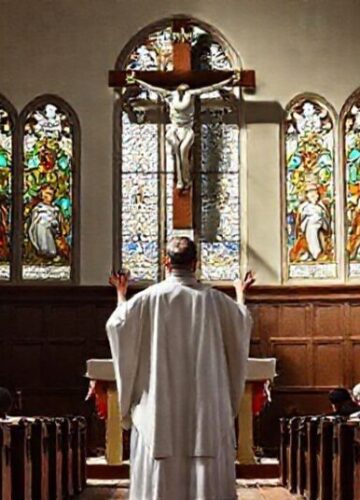 Prawdziwe chrześcijaństwo w tradycyjnym kościele katolickim Tradycyjny wnętrze kościoła katolickiego z ks. w białej szacie modlącego się przed ołtarzem, tłem duży krzyż i wierni na kolanach.