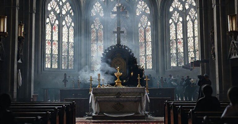 Wnętrze katolickiego kościoła z częściowo spalonym ołtarzem i hostią w monstrancji, symbolizujące profanację miejsc kultu w Kanadzie.