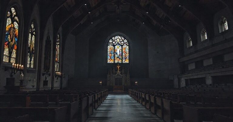 Wnętrze tradycyjnego kościoła katolickiego kontrastujące z pustą areną Spodku w Katowicach; symbolizuje profanację sakrum przez secolarny spektakl "Katedra".