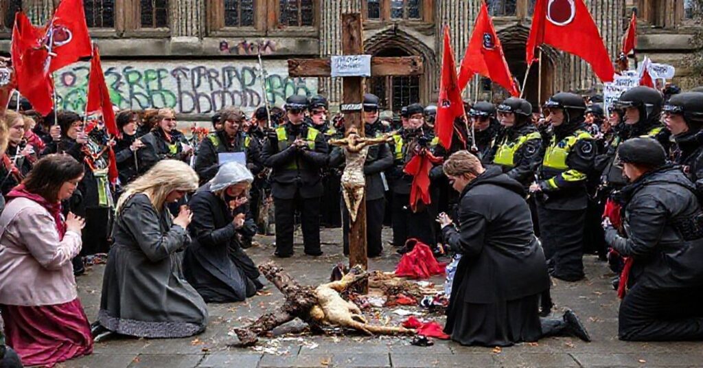 Tradycyjni katoliccy aktywiści pro-life modlą się przed profanowanym krzyżem podczas gwałtownego kontrprotestu Antify na Uniwersytecie w Manchesterze.