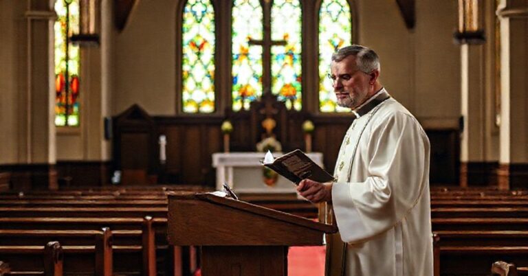 Solemne wnętrze kościoła z tradycyjnymi witrażami i kazalnicą przyozdobioną gazetą „Gość Niedzielny”.