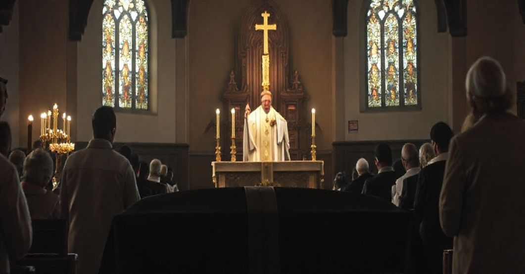 Uroczysta katolicka msza pogrzebowa w tradycyjnym kościele, z kapłanem w sutannie i biało-srebrnym ornacie, podnoszącym monstrancję z Najświętszym Sakramentem. Nawa kościoła jest przyciemniona, z witrażami rzucającymi delikatne światło. Na pierwszym planie trumna pokryta czarną pallą, otoczona żałobnikami w tradycyjnych strojach, z głowami pochylonymi w modlitwie. Scena podkreśla powagę śmierci i potrzebę modlitw za zmarłych z perspektywy sedewakantyzmu.