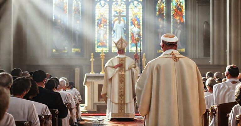 Biskup w pełnym stroju liturgicznym przed ołtarzem podczas uroczystości Chrystusa Króla Wszechświata
