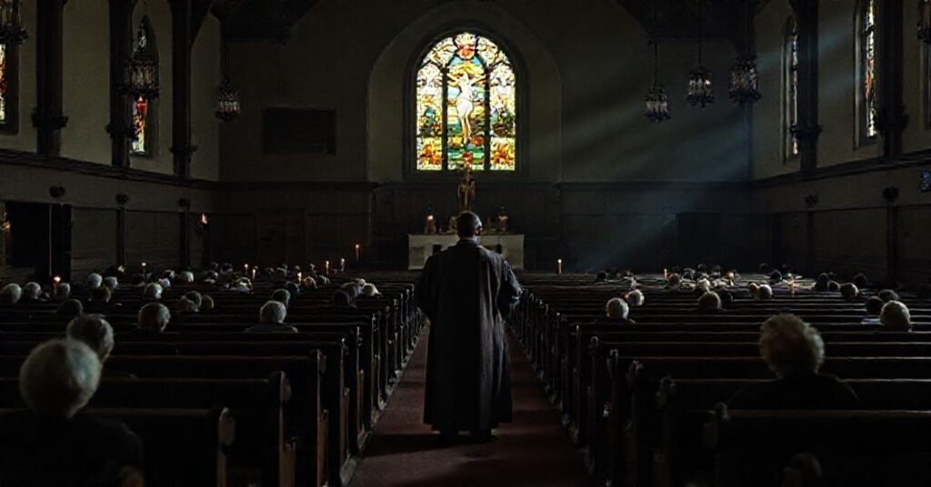 Wnętrze opuszczonego kościoła w Dubuque z jednym księdzem w kaszule i surply w pustym sanktuarium.