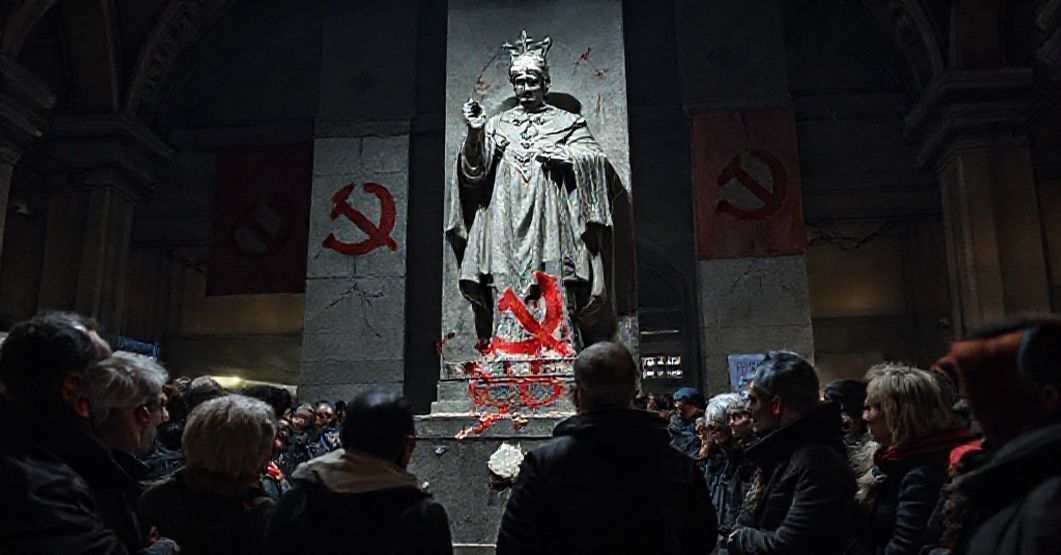 Zbezczeszczenie pomnika Jana Pawła II: symptom nowoczesnej apostazji Zbezczeszczony pomnik Jana Pawła II przy rzymskim dworcu Termini z komunistycznym symbolem sierpem i młotem, otoczony zbulwersowanymi wiernymi tradycyjnymi.