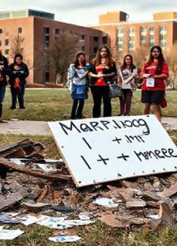 Zniszczone stoisko tradycyjnego małżeństwa na kampusie Uniwersytetu Stanu Oklahoma z grupą studentów w modlitwie